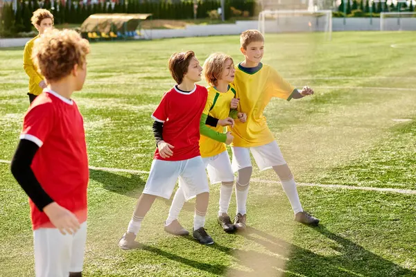 Um grupo alegre de crianças pequenas estão triunfalmente em cima de um campo de futebol, unidos na vitória e camaradagem após um jogo. — Fotografia de Stock