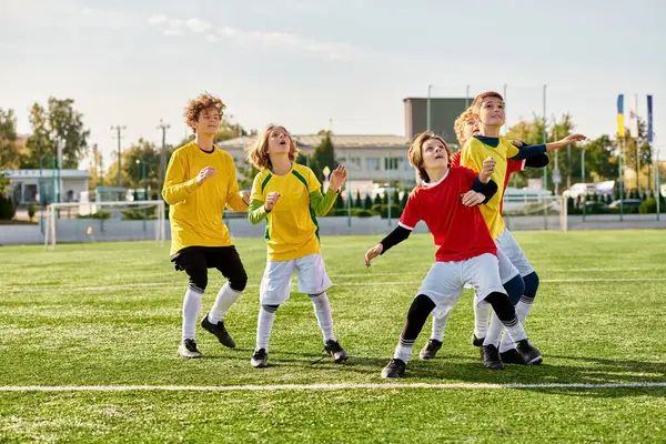 Un groupe dynamique de jeunes individus joue avec enthousiasme à un jeu de football, de course, de passe et de tir vers le but dans un match compétitif et amusant. — Photo de stock