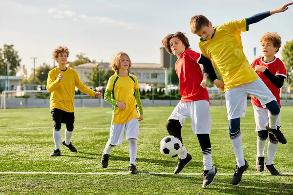 Eine Gruppe junger Jungen kickt fröhlich um einen Fußball, zeigt ihr Können und baut bei einem Freundschaftsspiel Kameradschaft auf.. — Stockfoto
