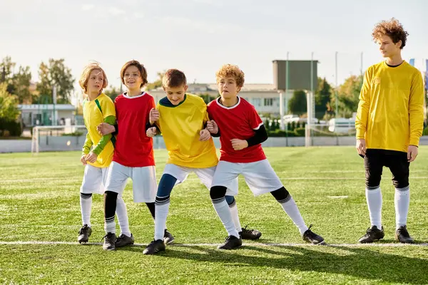 Живая группа молодых людей гордо стоит на вершине футбольного поля, излучая энергию и энтузиазм. Они объединены в своей любви к игре, их товарищество очевидно в их улыбки и позы. — стоковое фото