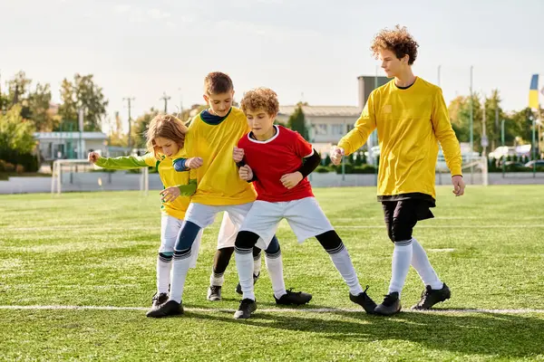 Eine Gruppe tatkräftiger junger Jungen steht in ihren Fußballtrikots stolz auf dem Gipfel eines Fußballfeldes und zeigt Teamwork und Kameradschaft in dem Sport, den sie lieben.. — Stockfoto