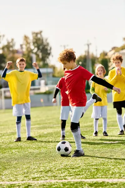 Un grupo de niños enérgicos jugando con entusiasmo un juego de fútbol, pateando la pelota y tratando de marcar goles en un día soleado en el parque. - foto de stock