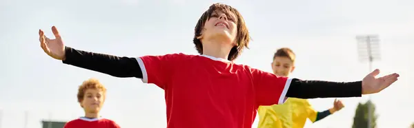 Un groupe animé de jeunes hommes jouant avec enthousiasme un jeu de frisbee dans un champ herbeux, avec des frisbees volant dans les airs et des joueurs courant et riant. — Photo de stock