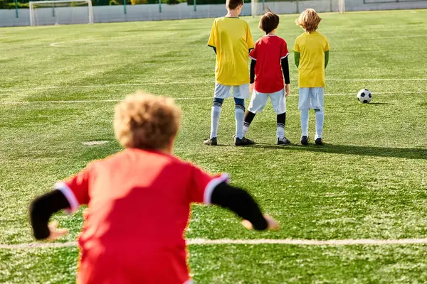 Eine Gruppe junger Männer steht stolz auf einem gepflegten Fußballplatz, ihre Mienen strahlen Entschlossenheit und Begeisterung aus. Sie feiern einen hart erkämpften Sieg und genießen das Gefühl des Triumphes in ihrem Sport. — Stockfoto