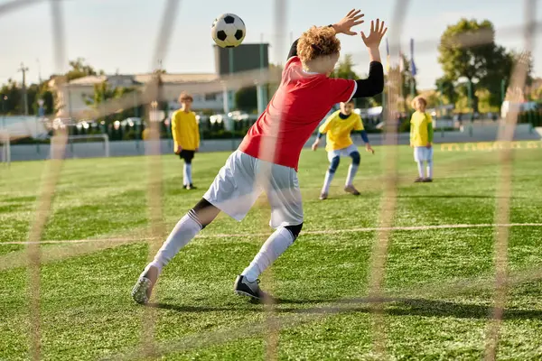 Una scena dinamica si svolge mentre un gruppo di giovani compete ferocemente in un gioco di calcio, sprint, passaggio e tiro verso l'obiettivo con innegabile passione e abilità.. — Foto stock