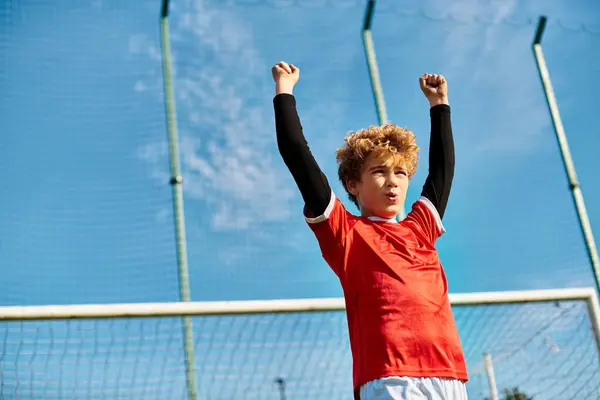 Un ragazzo si erge con sicurezza su un campo da tennis, con una racchetta da tennis in mano. Sembra concentrato e pronto a fare un gioco.. — Foto stock
