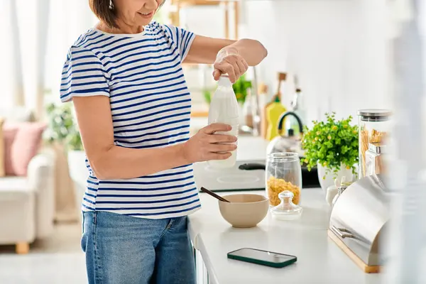 Жінка в затишному домашньому вбранні, стоячи на кухні, готуючи їжу. — стокове фото