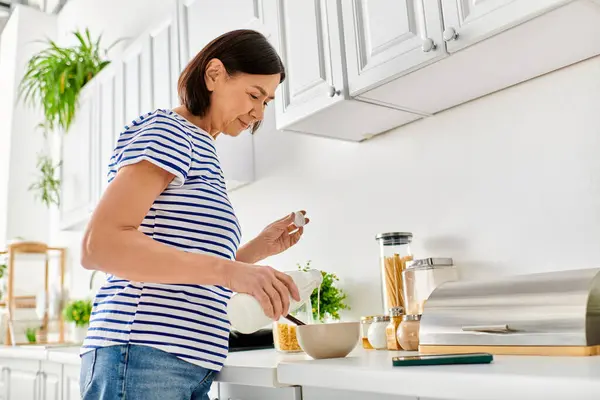 Una donna in accogliente casalinghi si trova in una cucina, assorto nella preparazione del cibo. — Foto stock