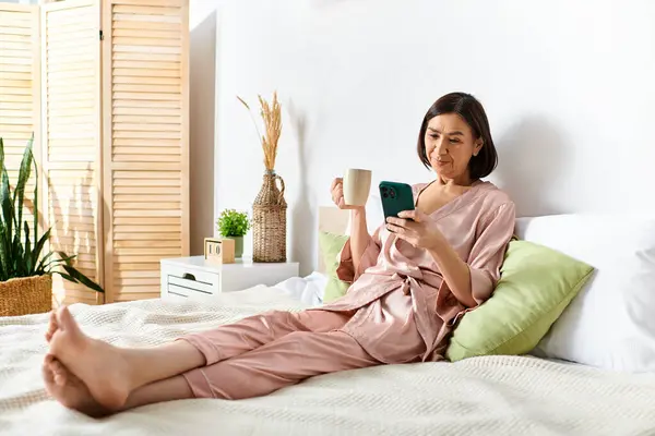 An elegant woman in cozy homewear enjoys a peaceful moment on a bed, engrossed in a book. — Stock Photo