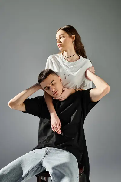 Ein Mann balanciert auf den Schultern einer Frau in einem Studio vor grauem Hintergrund. — Stockfoto