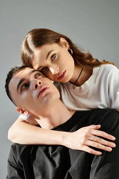 A young man and woman, deeply in love, elegantly pose together for a picture in a studio with a grey background. — Stock Photo