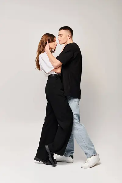 A young man and woman share an intimate dance in a studio, their bodies moving gracefully in sync to the music. — Stock Photo