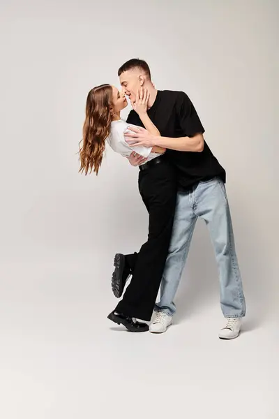 Un uomo e una donna condividono un bacio appassionato in un ambiente di studio, esprimendo amore e tenerezza in un momento di connessione. — Foto stock