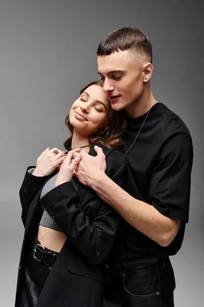 A man and a woman embrace each other in a tender moment of love and connection, against a soft grey background. — Stock Photo