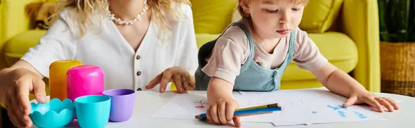 Una madre dai capelli ricci e sua figlia bambino si siedono a un tavolo, impegnandosi in attività di apprendimento Montessori in un ambiente accogliente casa. — Foto stock