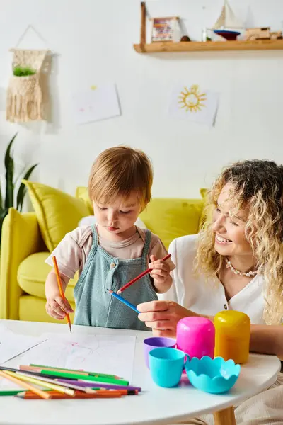 A curly mother and her toddler daughter engage in Montessori education at a table, immersed in a world of learning and discovery. — Stock Photo