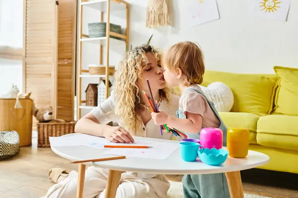 A mother with curly hair and her toddler daughter sit at a table, engaged in Montessori activities to foster early education. — Stock Photo