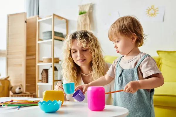 A curly-haired mother and her toddler daughter are immersed in playtime, utilizing Montessori educational toys at home. — Stock Photo