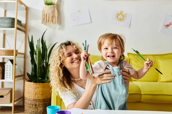 Eine lockige Mutter und ihre kleine Tochter unternehmen Montessori-Lernaktivitäten an einem Tisch in gemütlicher häuslicher Umgebung. — Stockfoto