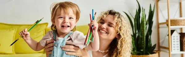 Lockige Mutter und ihre kleine Tochter mit Buntstiften nach Montessori-Methode. — Stockfoto