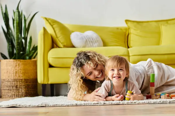 A woman and child with curly hair engage in Montessori education together on the floor, fostering a nurturing bond. — Stock Photo