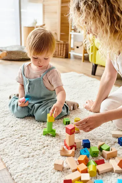 Curly-haired mother lovingly engaging with her toddler daughter using Montessori education method at home. — Stock Photo