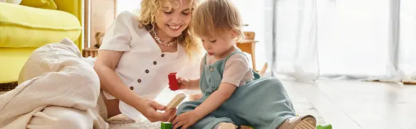 Une mère aux cheveux bouclés et sa petite fille jouent activement avec les jouets Montessori sur le sol, favorisant un lien fort. — Photo de stock