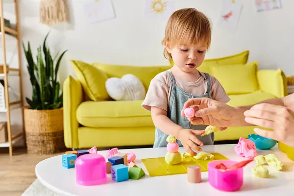 Uma mãe de cabelos encaracolados se envolve no método Montessori com sua filha menor, brincando e aprendendo juntos em uma sala de estar acolhedora. — Fotografia de Stock