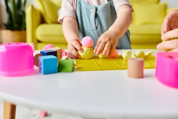 Une maman guide sa petite fille à travers Montessori en apprenant avec des blocs et des formes colorés. — Photo de stock