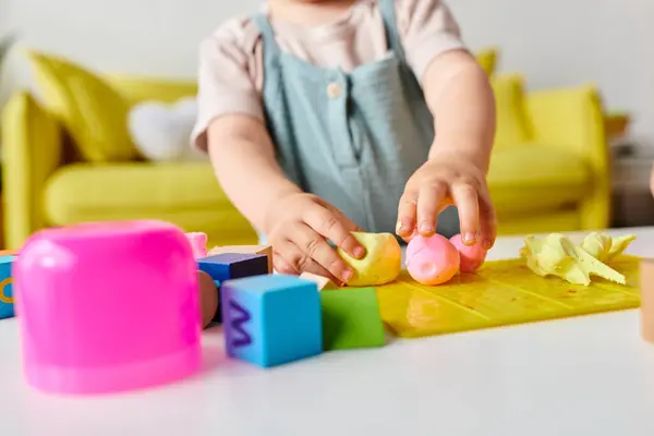 Kleinkind spielt und lernt fröhlich mit Montessori-Spielzeug auf dem heimischen Tisch. — Stockfoto