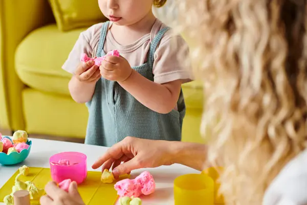 A curly-haired mother and her toddler daughter engage in the Montessori educational method, playing and bonding at home. — Stock Photo