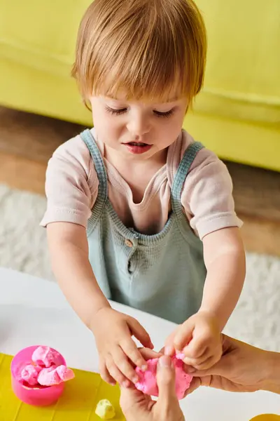 A young child plays happily with a dough, exploring the Montessori method of education at home. — Stock Photo