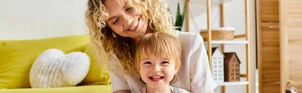 Une mère aux cheveux bouclés et sa petite fille partagent un moment Montessori rempli de rire à la maison. — Photo de stock