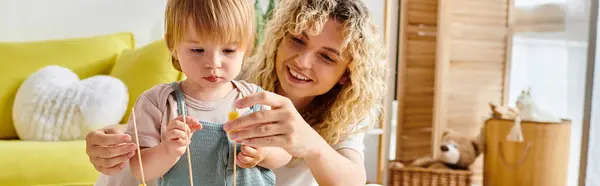 Une mère bouclée et sa petite fille interagissent de façon ludique avec une ficelle, explorant la méthode Montessori à la maison. — Photo de stock