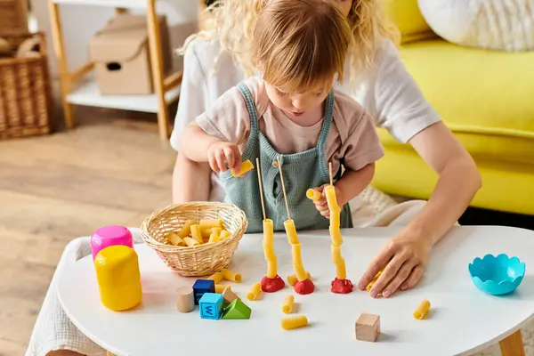 Curly mother and her toddler daughter engaging in Montessori play and learning at home. — Stock Photo