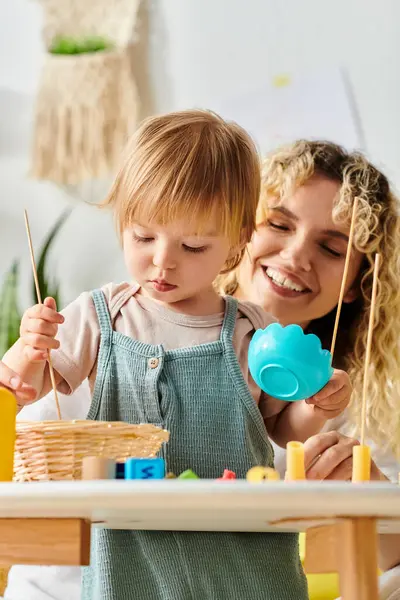 Uma mãe encaracolada e sua filha se envolvem em brincadeiras com brinquedos inspirados em Montessori em casa, promovendo a criatividade e a aprendizagem. — Fotografia de Stock