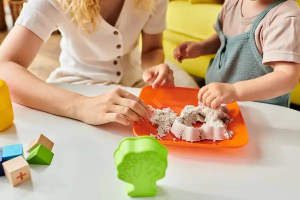 Mutter und ihre kleine Tochter genießen ein Montessori-inspiriertes Spiel am Tisch. — Stockfoto