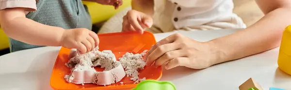 A child with mother is playfully experimenting with a plate using Montessori principles. — Stock Photo