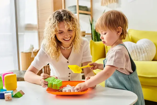 Eine lockige Mutter und ihre kleine Tochter genießen eine Montessori-artige Aktivität mit einer Schale, die das Lernen und die Verbindung fördert. — Stockfoto