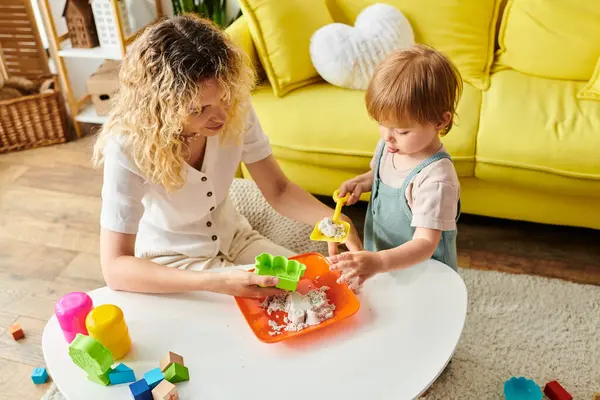 A curly-haired mother and her toddler daughter engage in the Montessori method, playing with toys at home. — Stock Photo