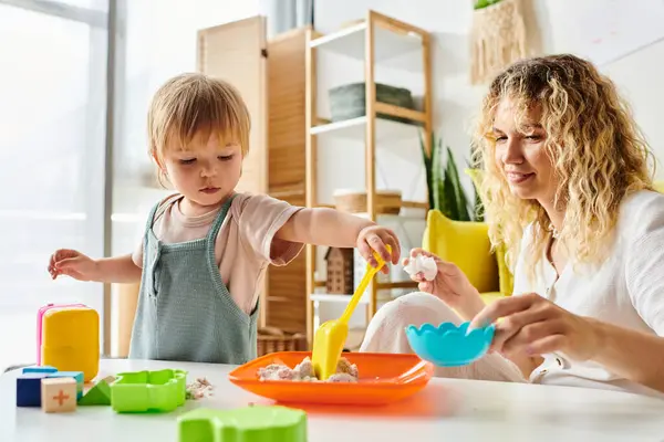 Curly mother and her toddler daughter explore Montessori toys together, fostering creativity and learning at home. — Stock Photo