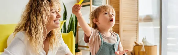 A curly-haired mother and her toddler daughter engage in playful activities using the Montessori education method at home. — Stock Photo