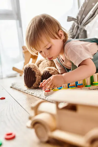Una madre riccia guarda mentre la sua bambina gioca felicemente con i giocattoli sul pavimento di casa, immersa nel metodo Montessori. — Foto stock