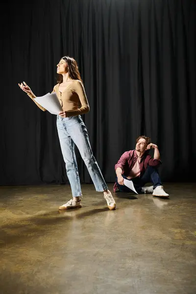 Женщина и мужчина, стоящие вместе на сцене во время репетиций. — стоковое фото
