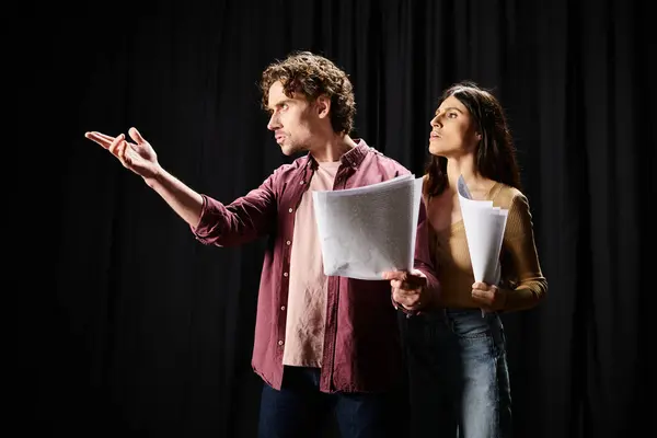 A man and woman rehearse together, holding papers. — Stock Photo
