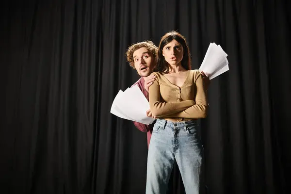 A man and woman review scripts together. — Stock Photo