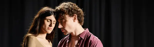A handsome man and a beautiful woman stand side by side, focused on rehearsing their roles in the theater. — Stock Photo