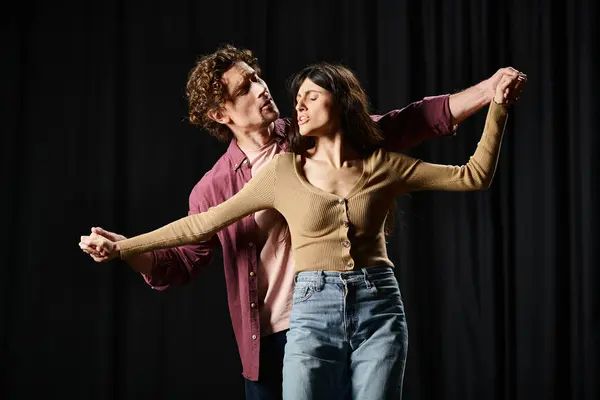 A man and a woman gracefully dance together in a theater rehearsal. — Stock Photo