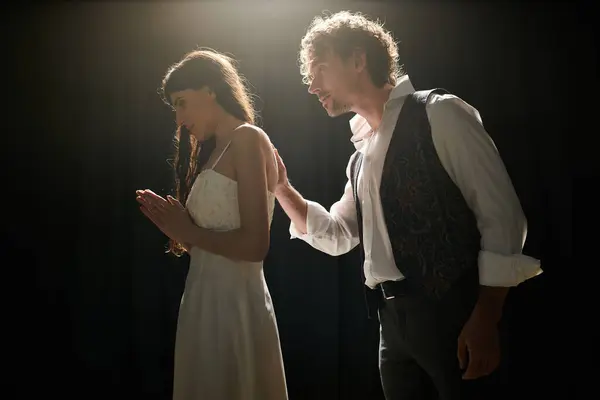 A handsome man and a beautiful woman stand side by side on stage during theater rehearsals. — Stock Photo
