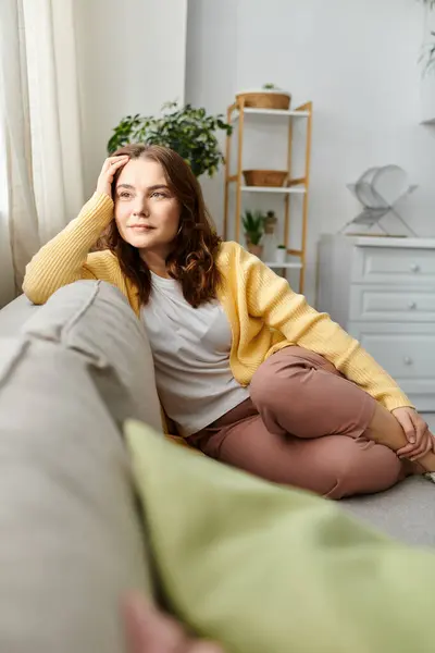 Femme d'âge moyen se détend paisiblement sur le canapé dans le salon confortable — Photo de stock